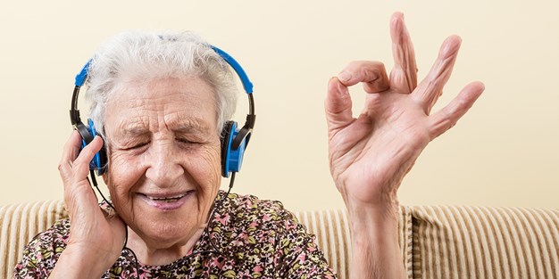 Senior person listening to headphones. Photo