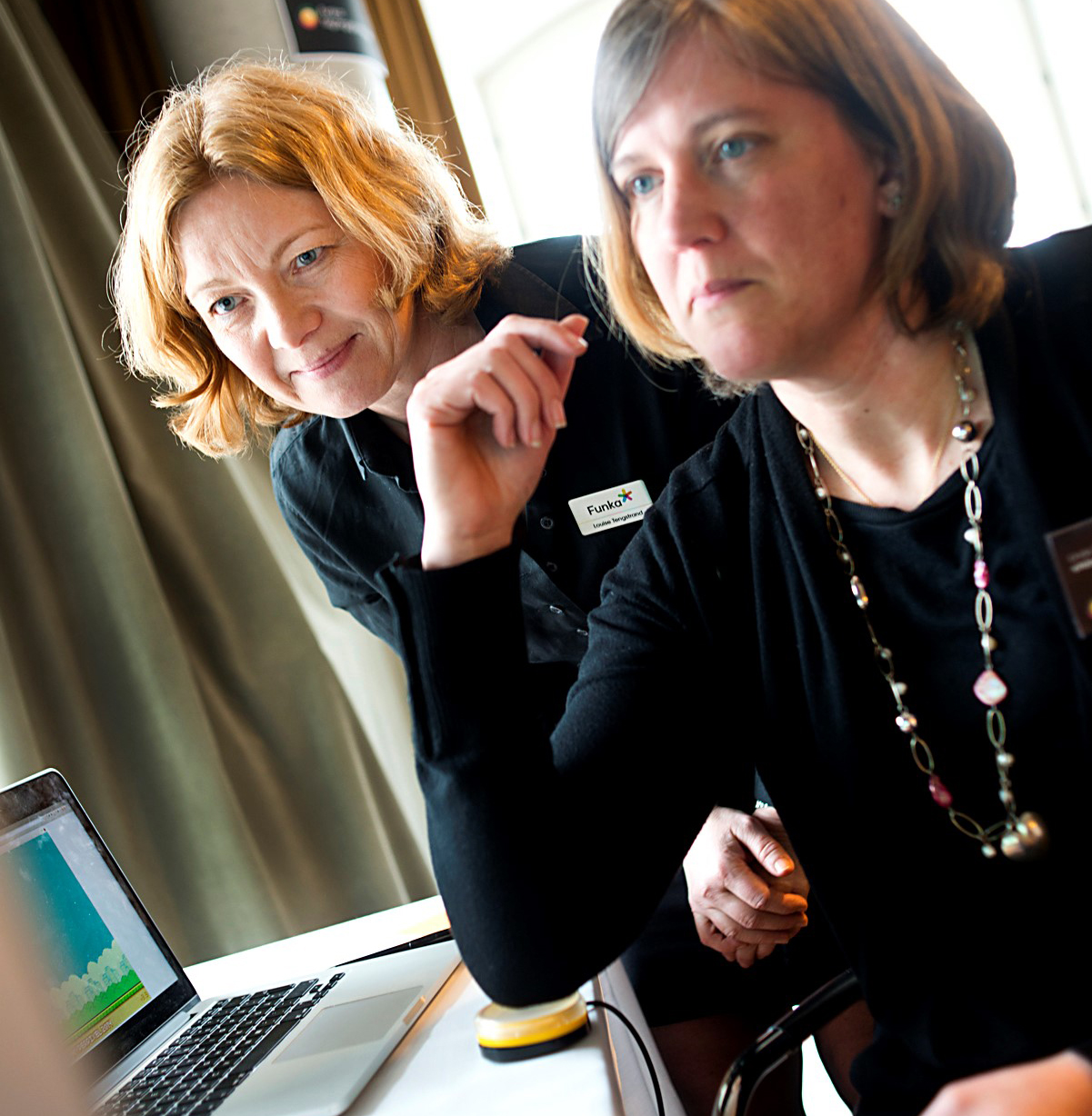 Funkas Louise Tengstrand och Linda Sjöberg från E-hälsomyndigheten testar spel med hjälpmedel. Foto