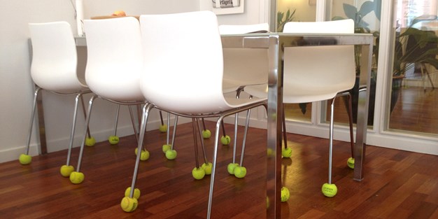 Stolar med tennisbollar fästa vid stolens ben för att dämpa ljud. Foto