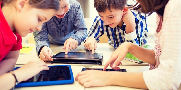 Children in school using tablets. Photo