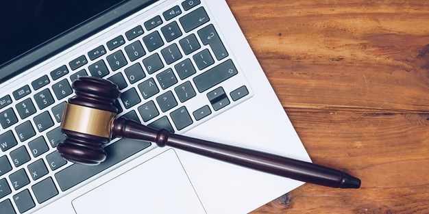 A judge hammer lying on a laptop. Photo