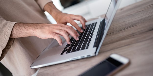 En person som använder en laptop. Foto