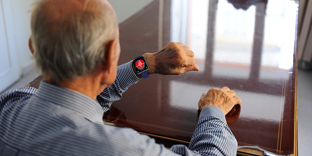 En äldre man som använder en smart klocka. Foto