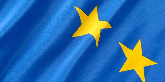Två gula stjärnor mot blå bakgrund i EUs logo. Foto