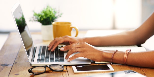 A person writing a report on a computer, photo.