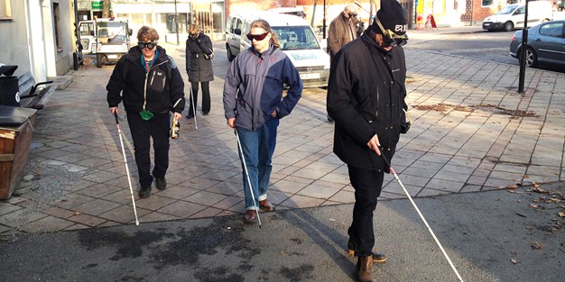 Two persons carry out Funka's empowerment exercise as visually impaired. Photo