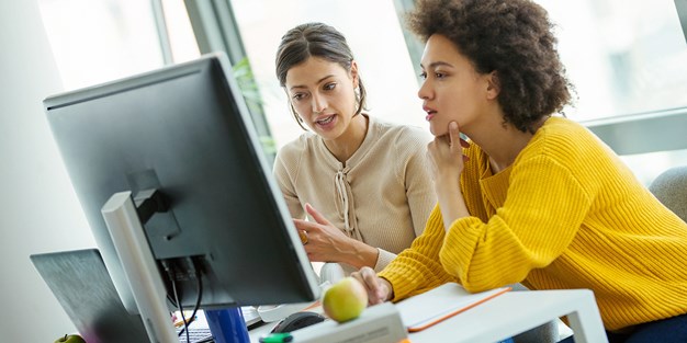 Two persons at work in front of their computers, photo.